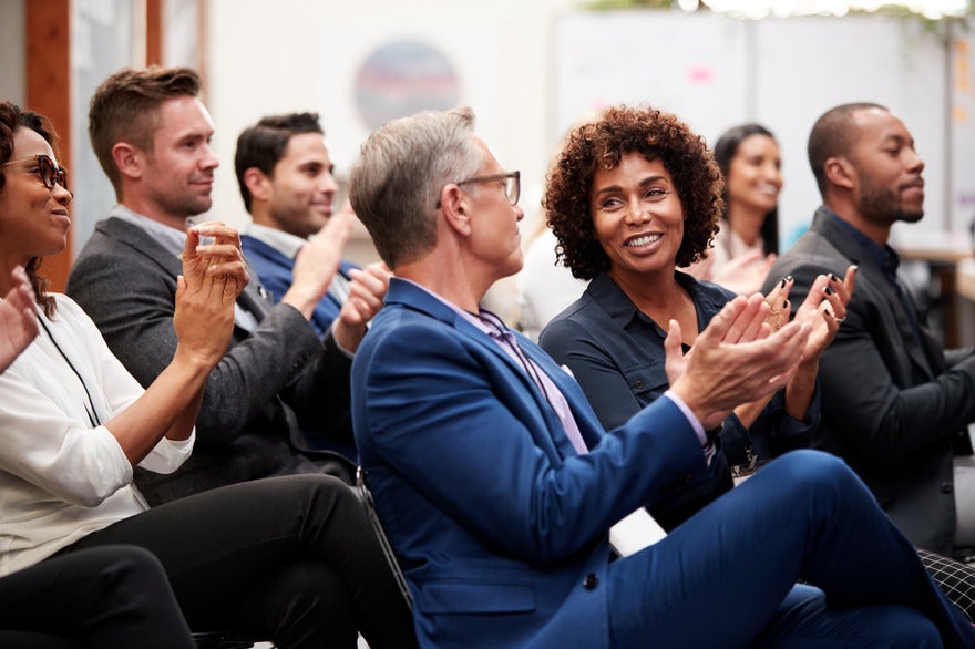 Global SEO conferences 2025 (1) Businessmen and women sat down at a conference and clapping