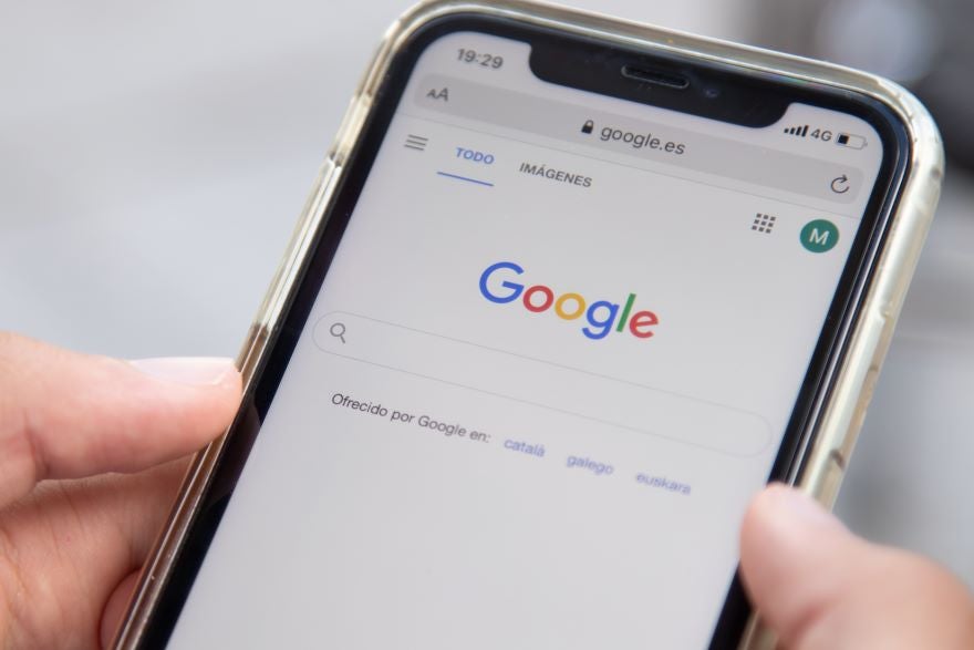 Google Page Annotations In Article Image A hand holding a phone with Google search on screen