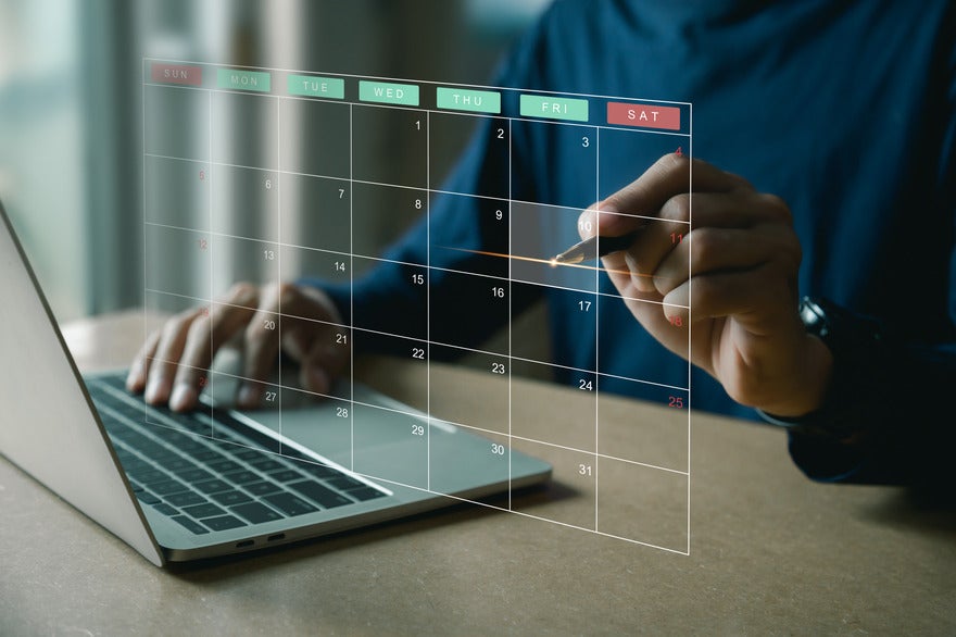 Marketing calendar 2025 See through calendar visual floating above a laptop with a person pointing to a date