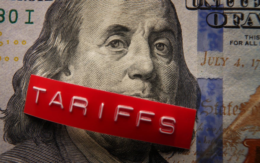 US tariff tracker US money with a printed label on top saying tariffs